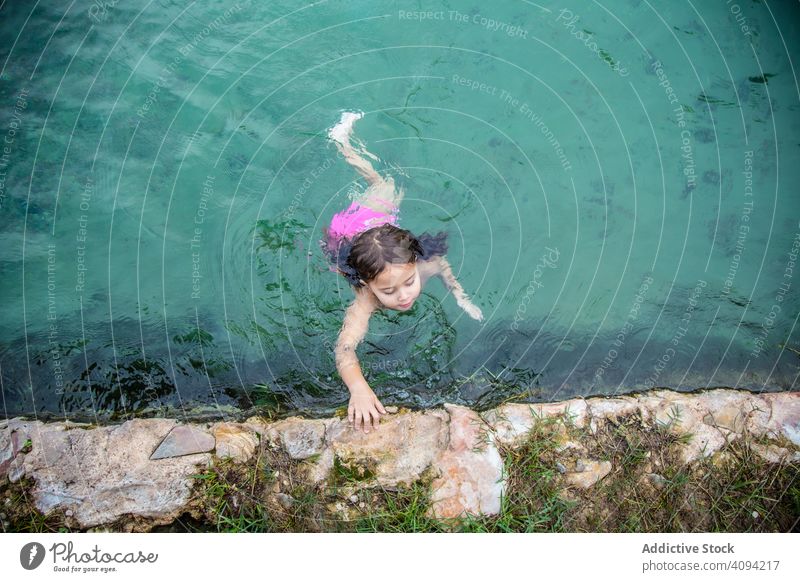 Mädchen schwimmt im Pool im Freibad schwimmen Spa Wasser Borte Spaß wenig Stein Beckenrand Kind Freude nass Resort sich[Akk] entspannen ruhen warm Herbst fallen