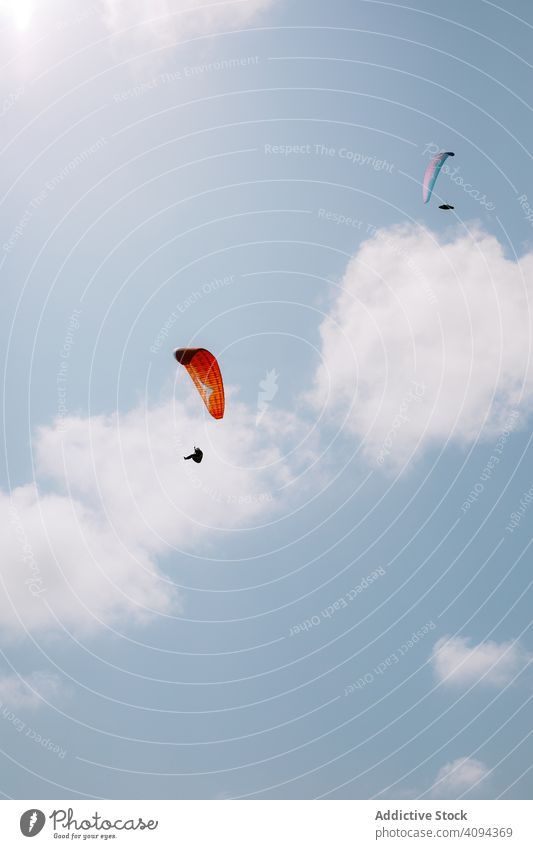 Gesichtslose Menschen beim Gleitschirmfliegen im blauen Himmel Fliege extrem Flügeltür Sport Abenteuer reisen Tourismus Freiheit Erholung Aktivität