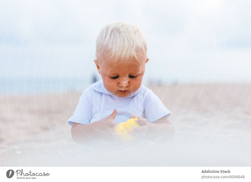 Kleiner Junge spielt mit Gummienten Sommer Strand Spielzeug spielen Unschuld Glück Ente wenig 5 Monate blond Leben wenig Kindheit Kinderbetreuung männlich