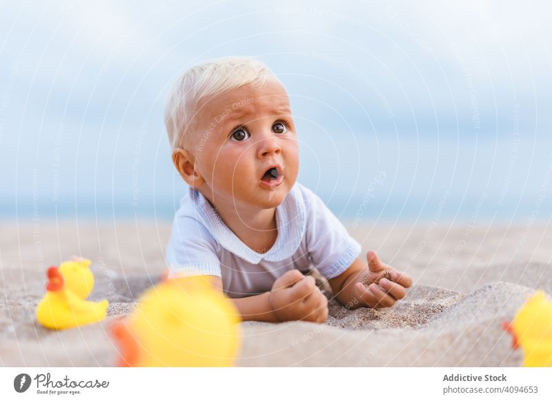 Kleiner Junge spielt mit Gummienten Sommer Strand Spielzeug spielen Unschuld Glück Ente wenig 5 Monate blond Leben wenig Kindheit Kinderbetreuung männlich