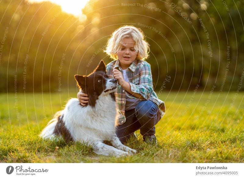 Kleiner Junge spielt mit seinem Hund im Freien im Park Menschen Kind kleiner Junge Kinder Kindheit lässig niedlich schön Porträt Lifestyle elementar Freizeit