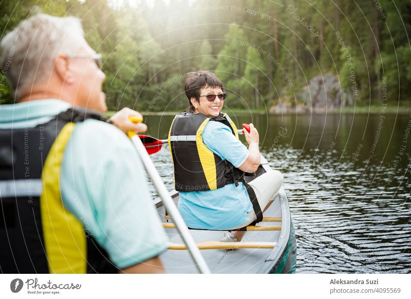 Glückliches reifes Paar in Rettungswesten Kanufahren im Waldsee. Sonniger Sommertag. Touristen, die in Finnland reisen und Abenteuer erleben. aktiv Aktivität