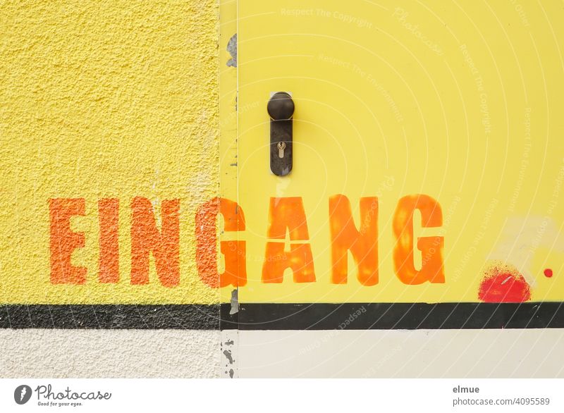 Gelb sind Wand und Tür gestrichen und über einem schwarzen Streifen ist in großen orangefarbenen Buchstaben EINGANG zu lesen / Farbe Eingang gelb Anstrich