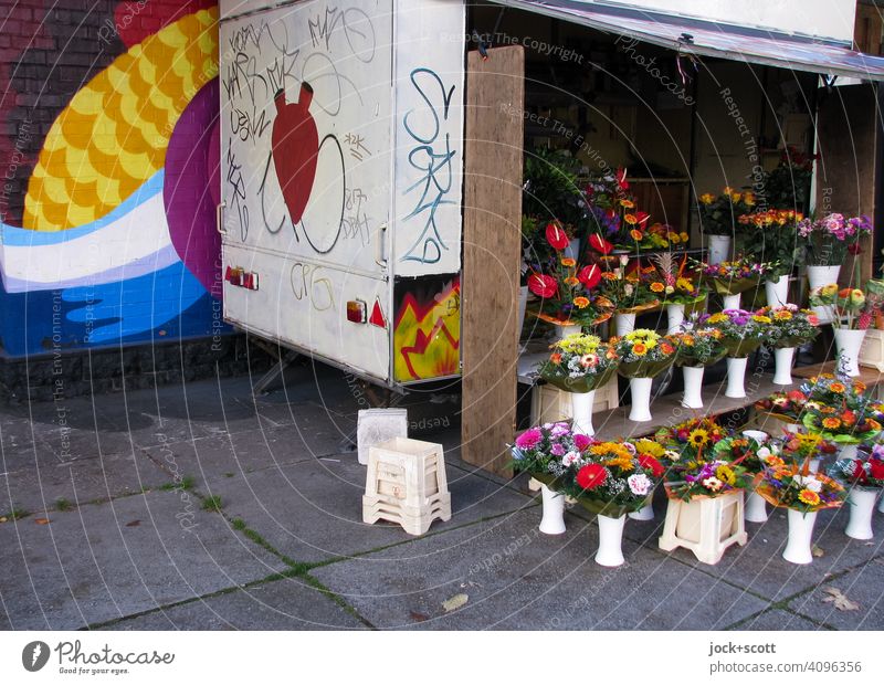 schäbiger Verkaufsanhänger mit frischen Blumensträußen Blumenstand Verkaufswagen Sortiment Auswahl authentisch geöffnet Graffiti Straßenkunst Schmiererei