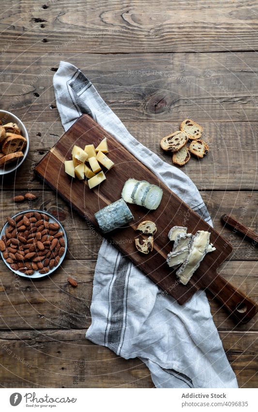 Croutons und Nüsse in Bretternähe mit Käse Holzplatte Tisch geschnitten Mandel Rosine Küche Lebensmittel hölzern Messer Brot Nut sortiert verschiedene Scheibe