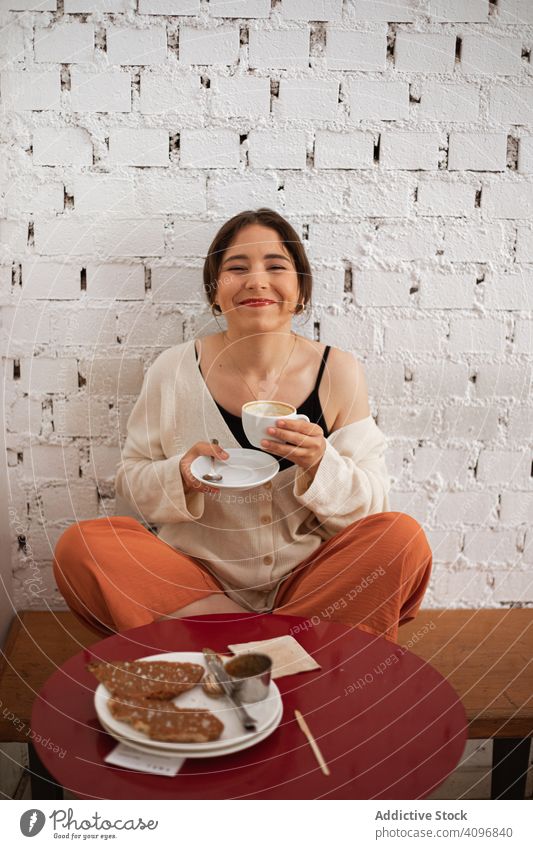Friedliche Frau trinkt Kaffee und ruht sich zu Hause aus heimwärts trinken friedlich Komfort entspannt heimisch Becher Küche Tisch Lebensmittel sitzen