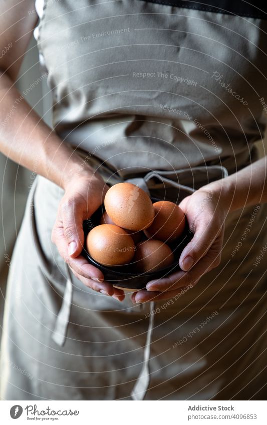 Gesichtslose Person hält Schüssel mit Eiern Koch frisch Essen zubereiten organisch Hähnchen Handvoll Bestandteil Lebensmittel Vorbereitung Gesundheit lecker