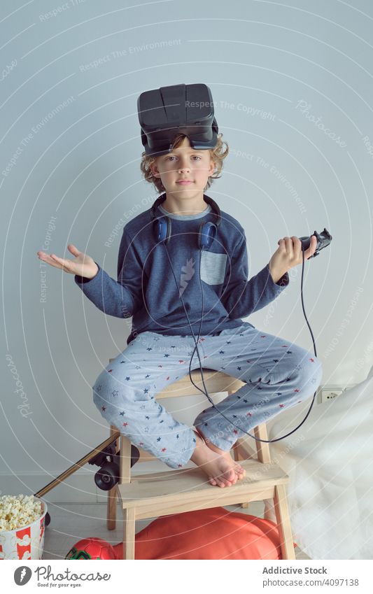 Junge mit VR-Brille auf dem Kopf schaut in die Kamera Schutzbrille Popkorn Entertainment Kälte träumen heimwärts Komfort Wochenende Kino Feiertag Headset Spaß