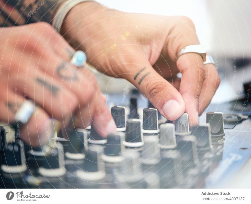 Anonymer DJ, der während der Party Musik auflegt dj Melodie Audioboard Mixer Arbeit Tattoo Club Schauplatz Ringe Entertainment Klang Schaltfläche drehen. Hand