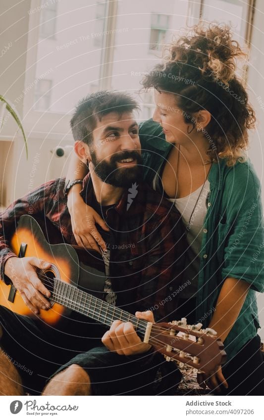 Fröhliches Paar spielt Gitarre zu Hause heiter Lachen heimwärts Spaß lässig spielen heimisch Hobby Musik Angebot Musiker Glück Gitarrenspieler Erwachsener