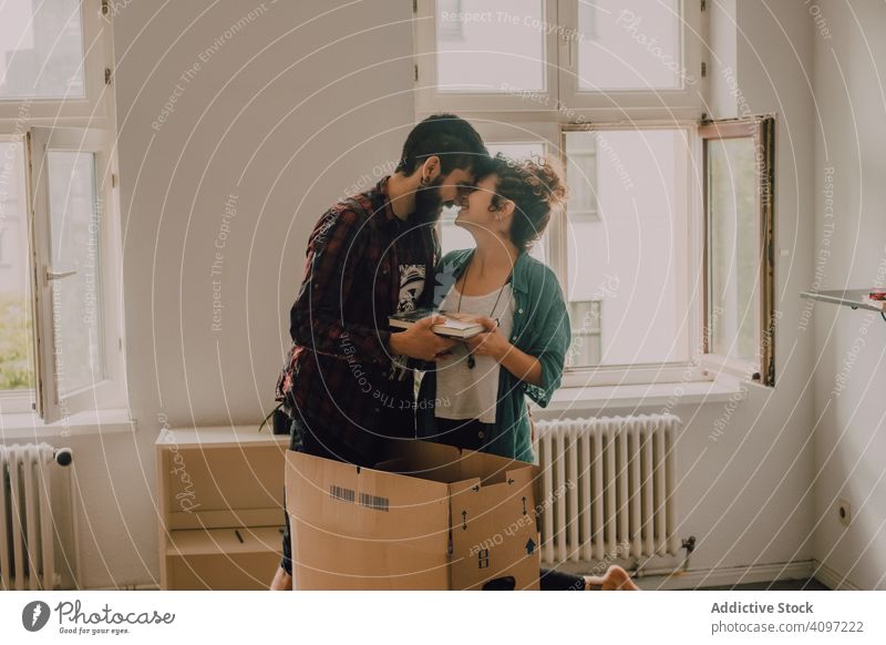 Lässiges Paar beim Auspacken von Kisten in der Wohnung auspacken Appartement Kasten lässig Hipster Zusammensein Barfuß Raum Licht heimisch heimwärts Haus Karton