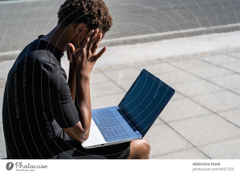 Verzweifelte Frau surft am Laptop und kommuniziert mit dem Handy Smartphone enttäuscht Verzweiflung benutzend Surfen Afroamerikaner Mobile reden Kommunizieren