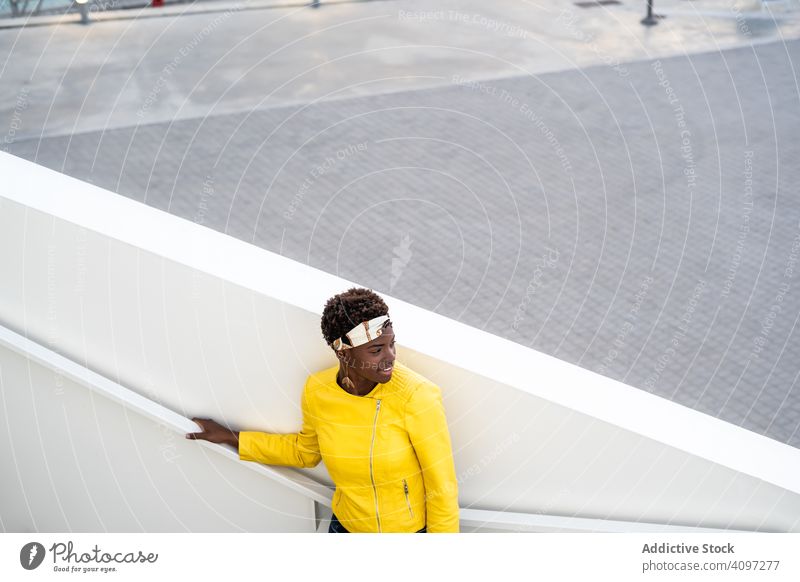 Zufriedene Frau beim Ausruhen auf einer Treppe in der Stadt Kälte Großstadt zufrieden froh Afroamerikaner stylisch anhaben Freizeit lässig jung heiter