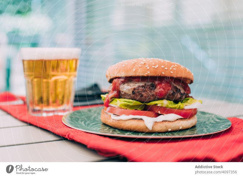 Cheeseburger mit Kopfsalat und Tomate Burger Brötchen klassisch ungesund Salat Tisch Lebensmittel Mahlzeit Zwiebel Rindfleisch lecker grillen Grillrost Snack
