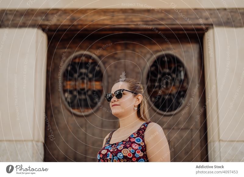 Frau mit Sonnenbrille auf dem Hintergrund einer Ziertür Stadt reisen Stil Tür träumen Freiheit ornamental Inspiration Straße sorgenfrei Architektur