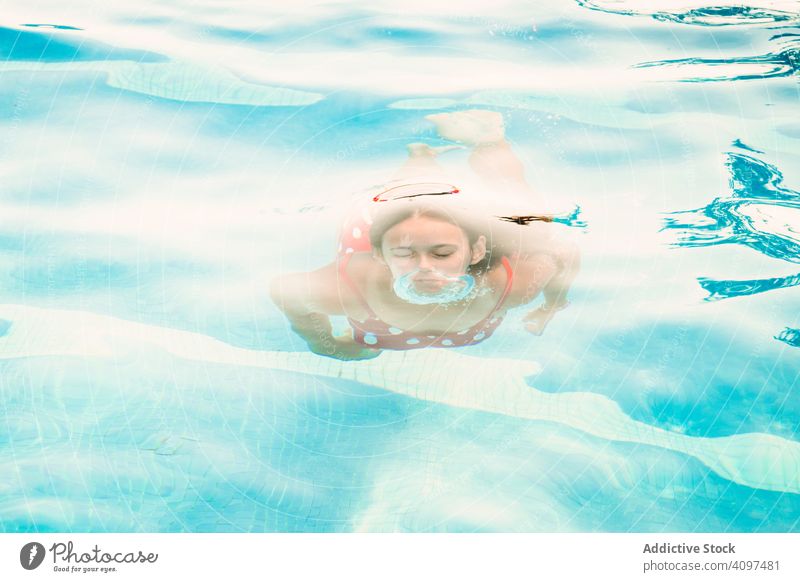 Glücklicher Teenager, der aus dem Schwimmbadwasser auftaucht Pool schwimmen Schaumblase Schlag Eintauchen Resort Spaß spielen Mädchen Wasser geschlossene Augen