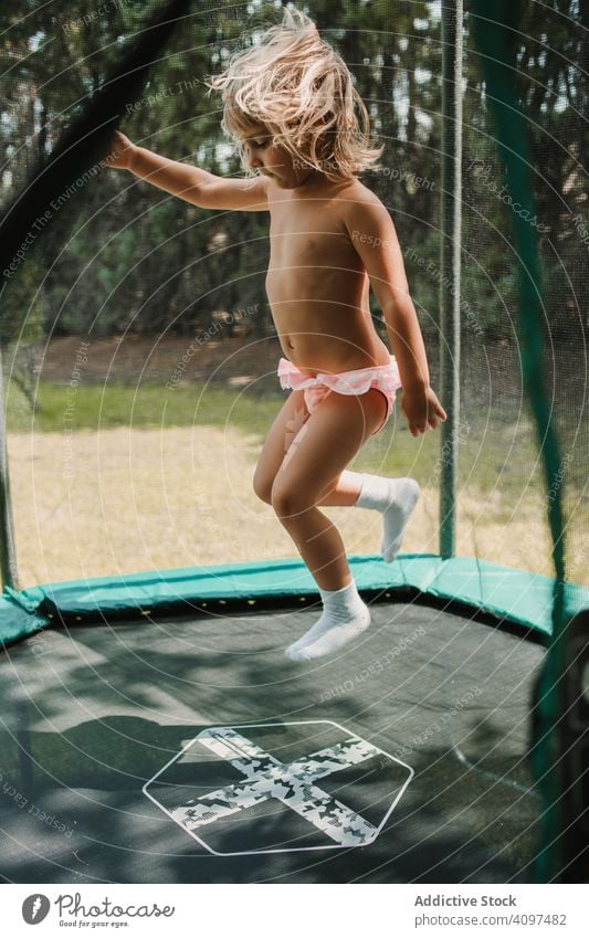 Kleines Mädchen springt auf Trampolin springen Garten Spaß Freude Glück Erholung Aktivität Lifestyle Spielplatz Sommer Übung Kindheit wenig Aktion Energie Kraft