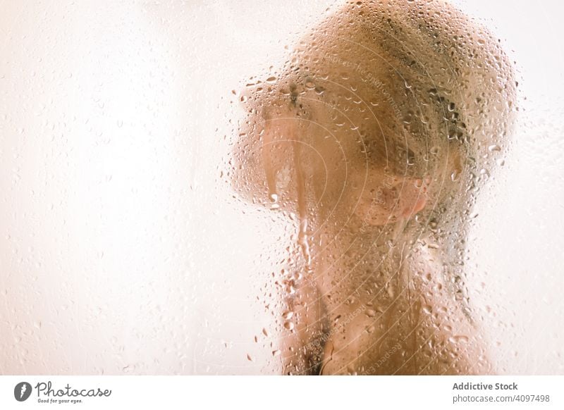 Frau hinter nassem Glas in der Dusche durchsichtig Abtrennung Bad Wasser Tropfen jung Pflege Körper Sauberkeit übersichtlich Hygiene sinnlich durchscheinend