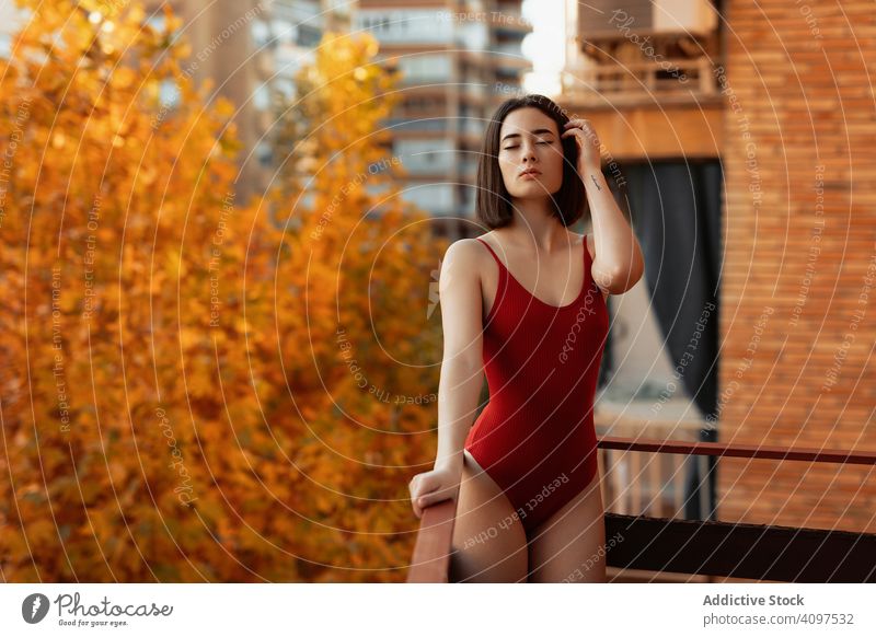 Hübsche Frau auf Balkon im Herbst stehend traumhaft glamourös verführerisch modisch stylisch Model Badeanzug Dessous attraktiv schick ernst sinnlich besinnlich