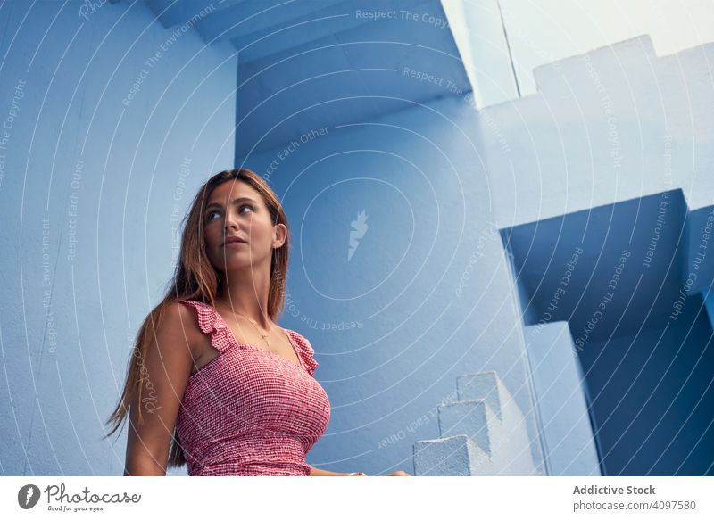 Frau geht die Treppe hinauf zum modernen blauen Gebäude lange Haare laufen nach oben elegant Konstruktion Struktur geometrisch Architektur urban Fassade