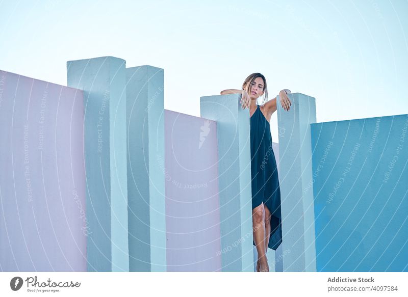 Frau steht auf der Spitze eines blauen Gebäudes lässig elegant Konstruktion Struktur geometrisch Architektur urban Fassade Wand abstrakt Außenseite Innovation