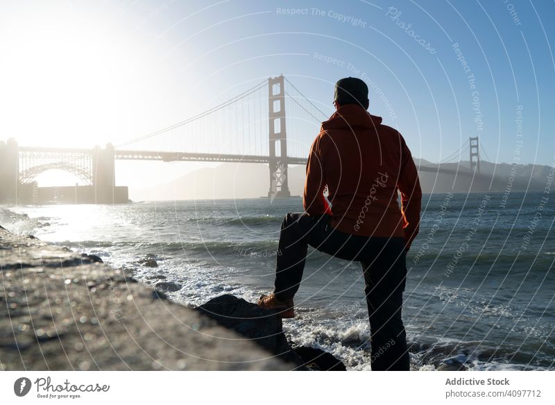Tourist mit Blick auf die malerische Brücke in einer ruhigen Bucht Starrer Blick friedlich MEER Küste Mann stehen entfernt bügeln Sonnenstrahlen winken Pier USA