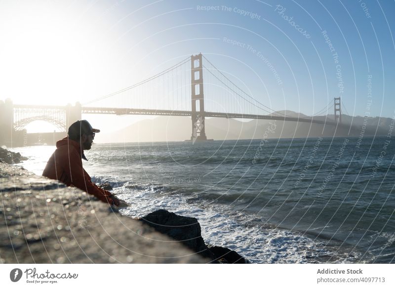 Tourist mit Blick auf die malerische Brücke in einer ruhigen Bucht Starrer Blick friedlich MEER Küste Mann stehen entfernt bügeln Sonnenstrahlen winken Pier USA