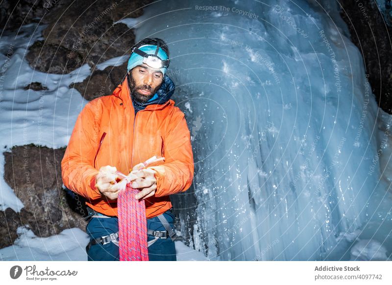 Müder Bergsteiger trägt Seil, während er am gefrorenen Gletscher steht Aufsteiger stehen führen müde bärtig Gerät Taschenlampe Dunkelheit Toubkal Afrika Marokko