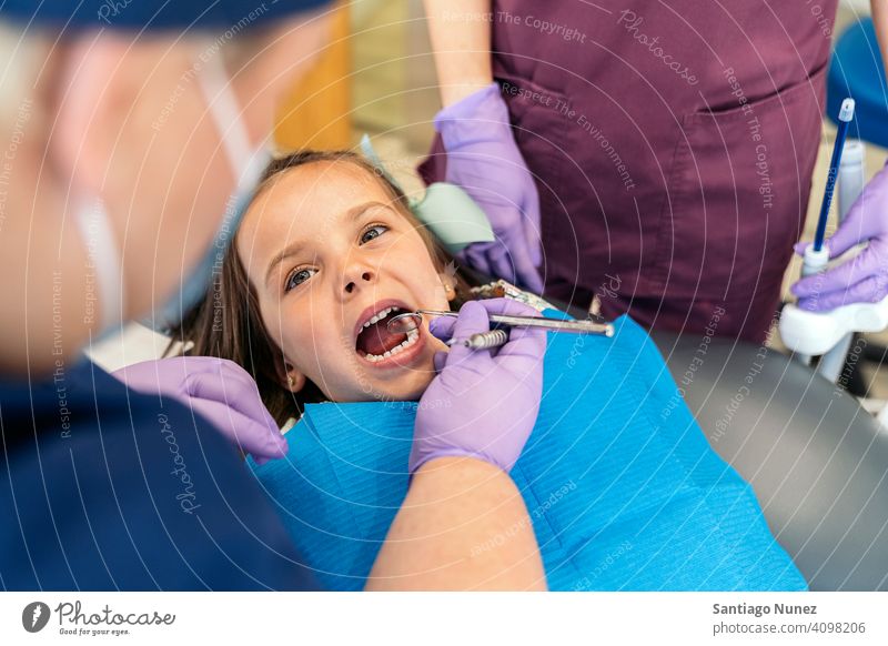 Junges Mädchen beim Checkup beim Zahnarzt Untersuchen Vorderansicht Kind jung aufschauend Klinik Dentalklinik geduldig Lügen Lächeln Gesundheit Pflege Gerät