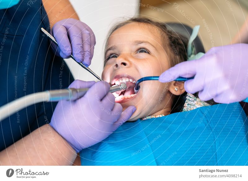 Junges Mädchen in Zahnarzt mit offenem Mund Nahaufnahme Reinigen Dentalwerkzeuge Untersuchen Vorderansicht Kind jung aufschauend Klinik Dentalklinik geduldig