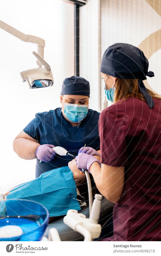 Zahnklinik Arbeiter mit jungen Patienten Seitenansicht Stehen zwei Frauen Blick geduldig Untersuchen Kind Mädchen Zahnarzt Klinik Dentalklinik Lügen Gesundheit