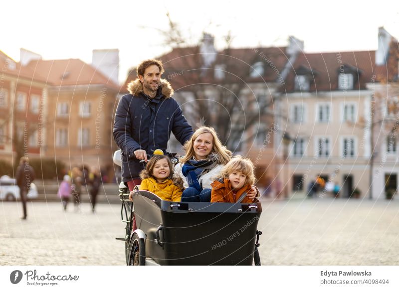 Junge Familie fahren in einem Lastenfahrrad zusammen Lastenrad Fahrrad Fahrradfahren Verkehr Dreirad Gesundheit aktiv Zyklus Radfahren modern