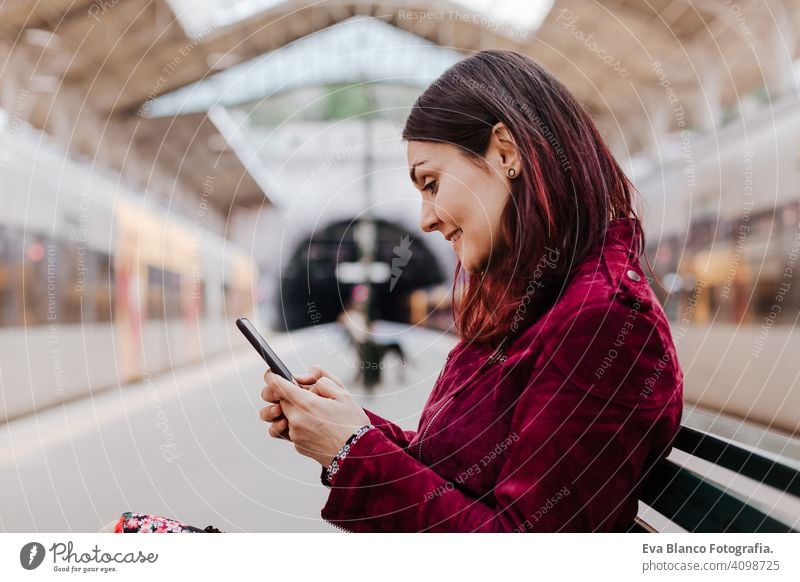 Nahaufnahme von schönen kaukasischen Frau im Bahnhof bereit zu reisen mit Handy. Reisen und Lifestyle-Konzept Technik & Technologie Smartphone Internet Gerät