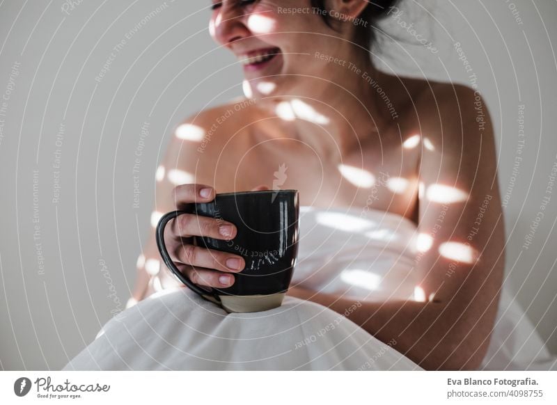 attraktive junge kaukasische Frau entspannt gut im Bett während der Morgenzeit. Dame genießt Tasse Kaffee im Schlafzimmer Frühstück trinken Getränk heiß Tee