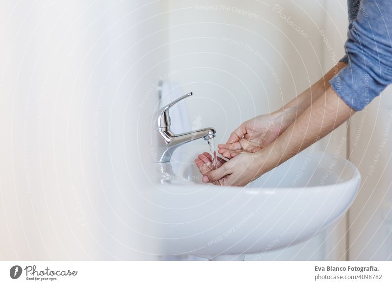 Nahaufnahme einer kaukasischen Frau, die sich im Badezimmer die Hände wäscht, um eine Covid-19-Virusinfektion zu verhindern. Empfohlenes Waschen mit Seife und fließendem Wasser während einer Coronavirus-Pandemie