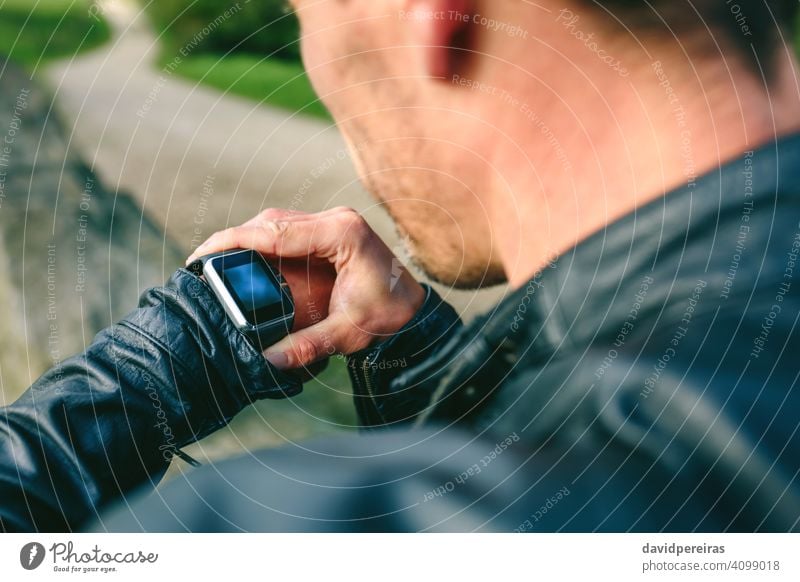 Unbekannter junger Mann schaut auf seine Smartwatch unkenntlich Hand smartwatch Blick Technik & Technologie zuschauen tragbar Mitteilung Bildschirm Touchscreen