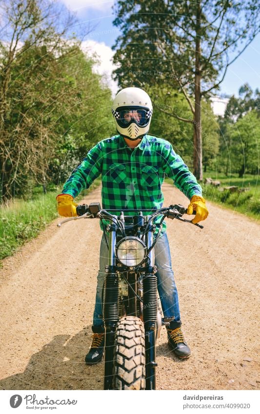Mann mit Helm auf einem Custom-Motorrad Biker trotzig benutzerdefiniert altehrwürdig Fahrrad retro Reiter Fahrzeug Verkehr posierend jung Erwachsener Menschen