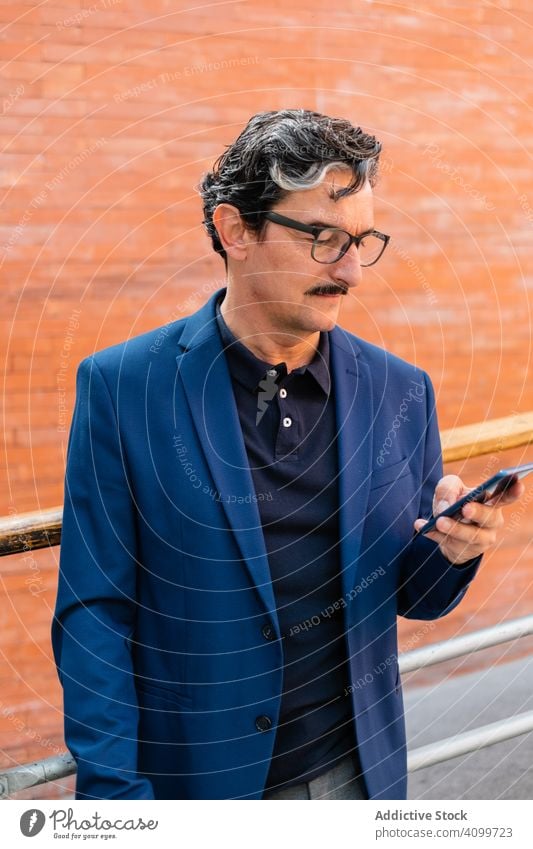 Senior-Geschäftsmann in blauer Jacke mit Smartphone Mann benutzend Browsen Surfen Mobile Telefon soziale Netzwerke zuschauend Texten Nachrichtenübermittlung