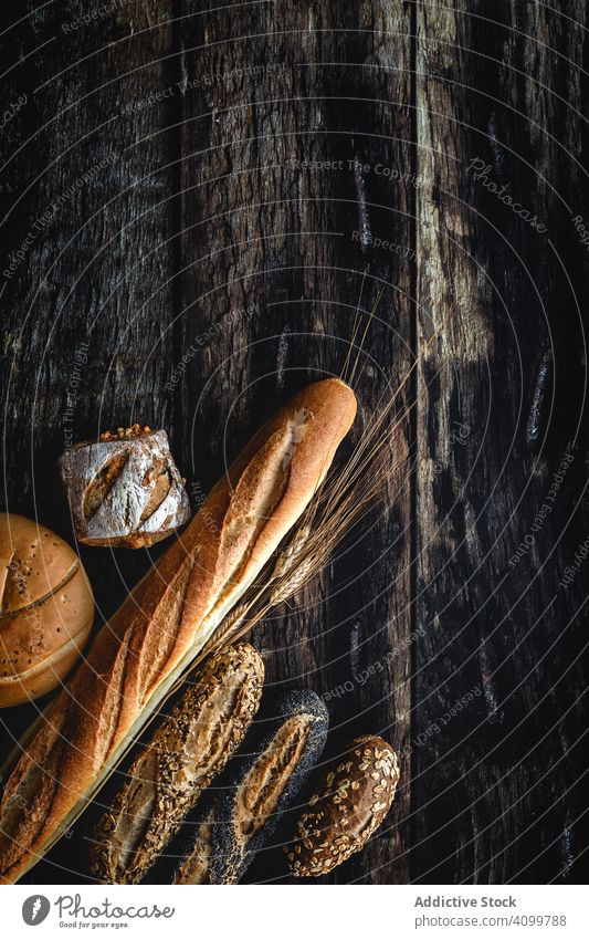 Assorted Gold hausgemachtes Brot auf dunklem Holz Hintergrund Lebensmittel Bäckerei Weizen Frühstück Anklopfen organisch rustikal Sortiment geschmackvoll