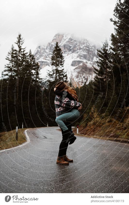 Lässig rastendes Paar in einer Umarmung auf einem Weg im Wald stehend Tourismus Stehen Umarmen Kiefer Berge Straße Route Autobahn reisen Natur Urlaub Abenteuer