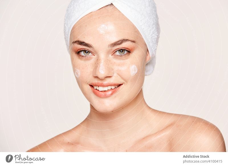 Entzückte Frau mit strahlender Haut beim Eincremen Sahne Pflege Spa Feuchtigkeit spenden sinnlich Teint Kosmetik Gesicht Gesundheit bewerben positiv erfreut