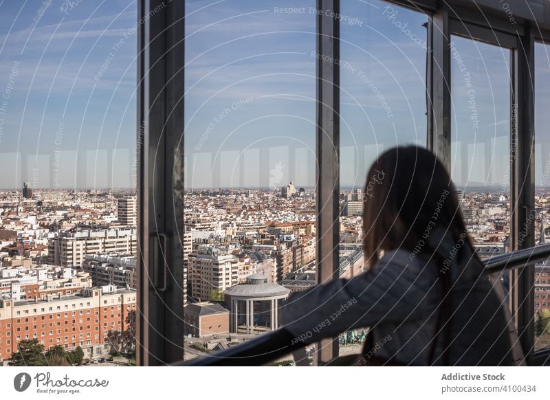 Anonyme Frau schaut aus dem Balkonfenster Fenster Großstadt bewundern Appartement ruhen modern heimwärts sonnig tagsüber sich[Akk] entspannen Lifestyle fettarm