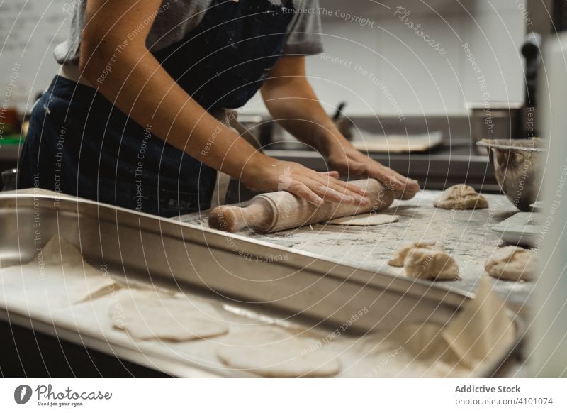 Bäcker rollt Teig in der Küche aus Teigwaren rollen Bäckerei Brot Lebensmittel Gebäck Mehl Mahlzeit Nudelholz Tisch Weizen Küchenchef Restaurant Vorbereitung