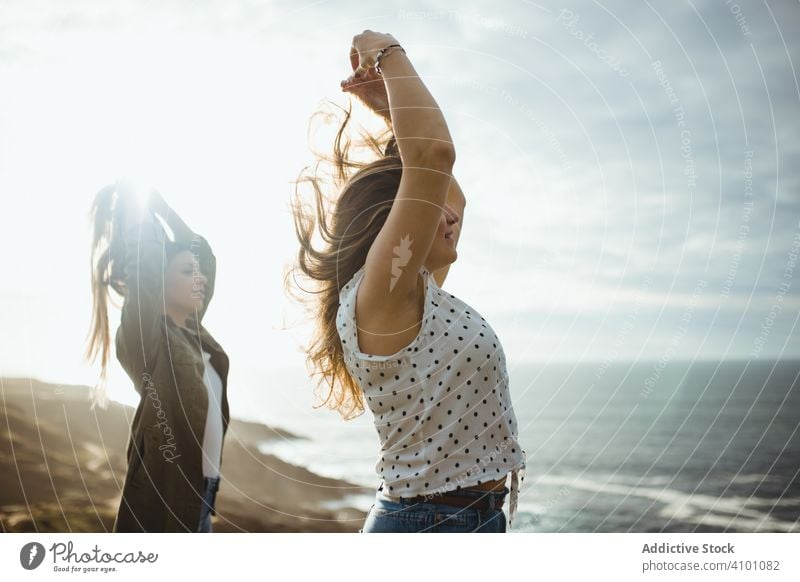 Glückliche weibliche Reisende genießen die Freiheit am Meer Frauen Seeküste Brise frisch fliegendes Haar Schwester stehen Harmonie Landschaft Zusammensein
