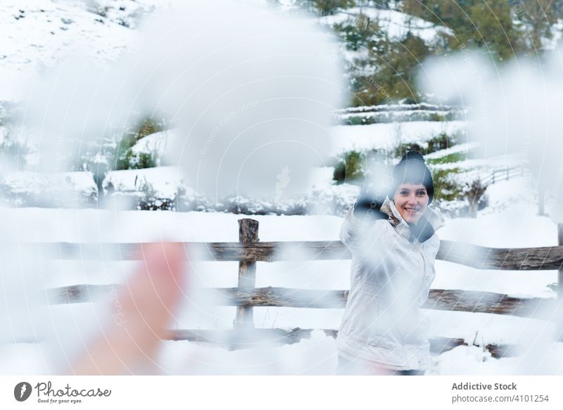 Lächelnde Frau spielt mit Schnee auf dem Land Schneeball Landschaft spielen Winter Freude Berge u. Gebirge ruhen Resort Feiertag Natur Dorf ländlich kalt Spaß