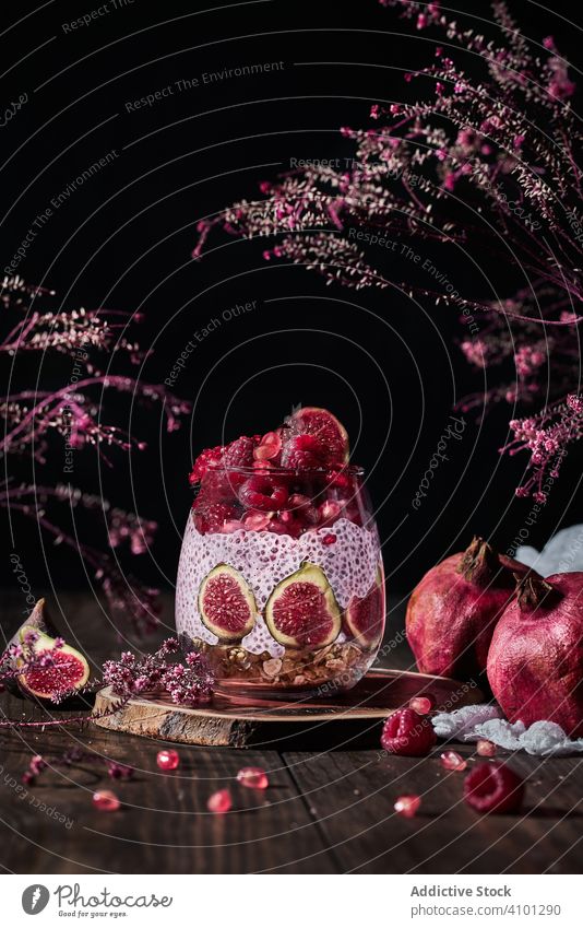 Chia-Pudding im Glas am Tisch Früchte frisch natürlich Himbeeren Granatapfel Feige gesättigt saftig reif lecker Dessert organisch Zutaten geschmackvoll