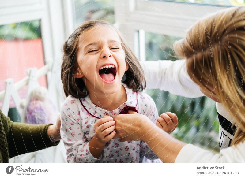 Niedliches kleines Mädchen lachend vom Kitzeln Lachen Kribbeln spielen Spaß Mutter Glück Familie Kind Kindheit wenig niedlich bezaubernd dunkles Haar freudig
