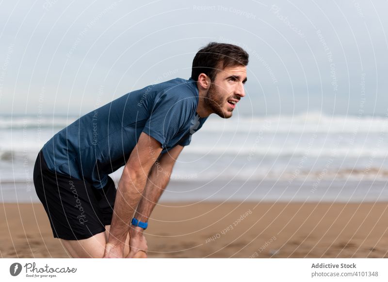 Sportler rastet am Strand Sand Seeküste Ufer Küstenlinie Meer Natur Sportkleidung Athlet Lifestyle Fitness Training Mann Aktivität Läufer Sportbekleidung