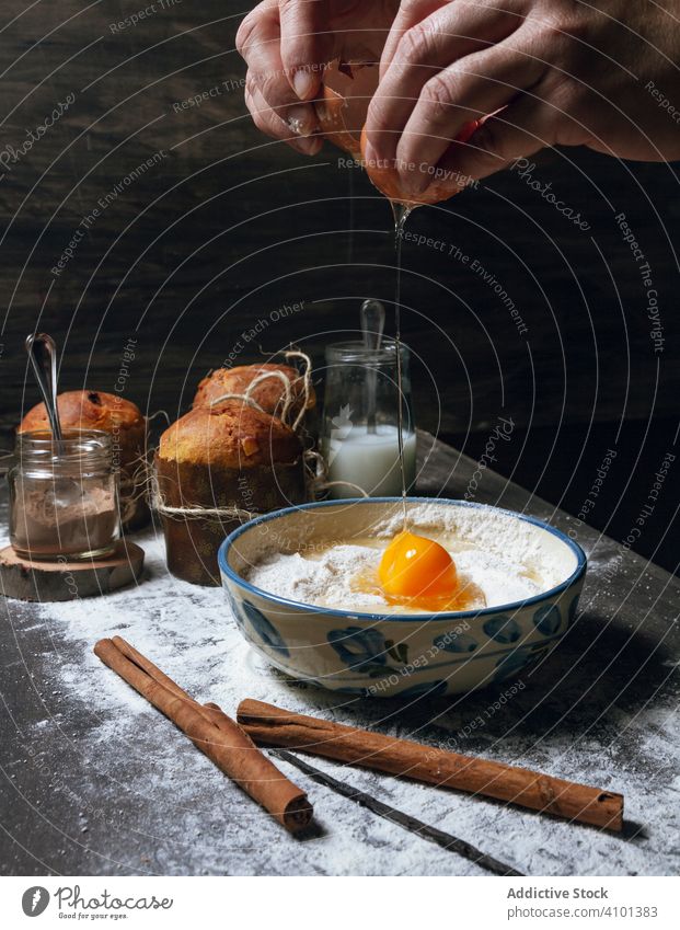 Ei über einer Schüssel mit Mehl aufschlagen Pause Panettone Kuchen Teigwaren Bestandteil Rezept backen Brot Hände vorbereiten Weihnachten Dessert Lebensmittel