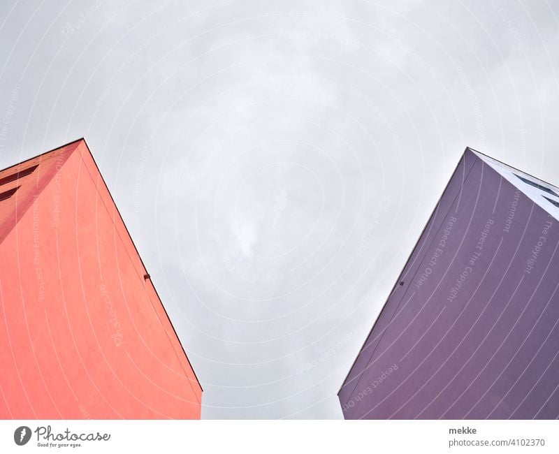 Farbenfrohe Fassaden umrahmen den bewölkten Himmel Neubau Hausfassade Hauswand Wolken DDR-Architektur Plattenbau Gebäude Beton Froschperspektive Berlin